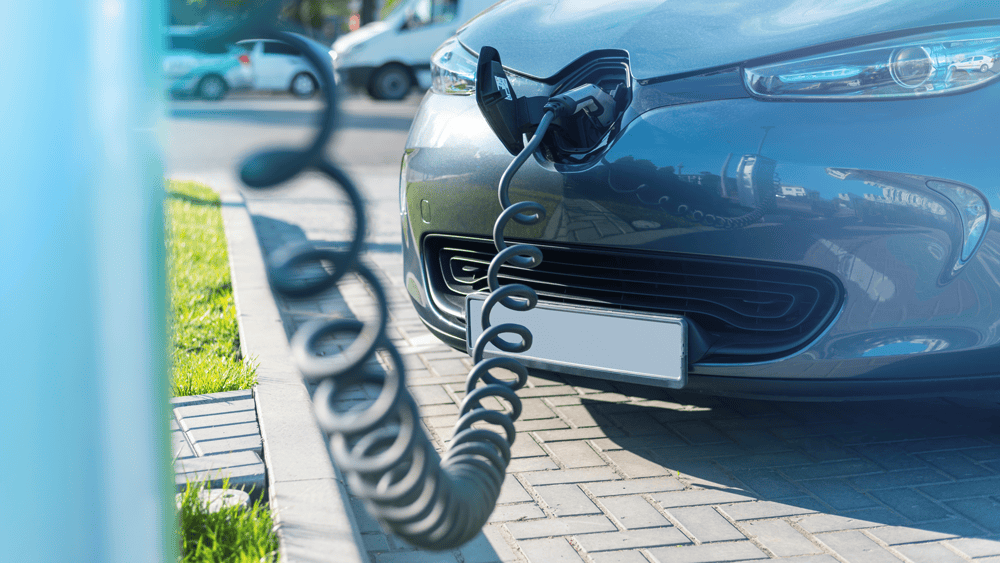 plugged charger into electric car charge station